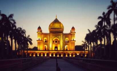 "Night view of Safdarjung Tomb illuminated with lights and reflecting on the water in front of it"