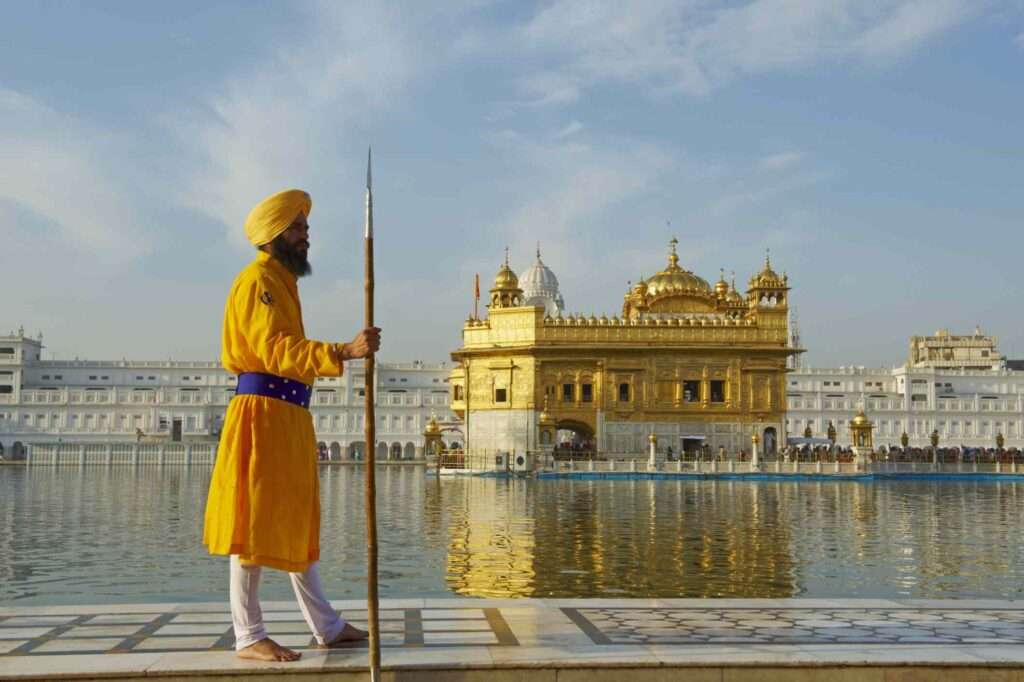 "A Punjabi man standing in front of the Golden Temple in Amritsar, India,