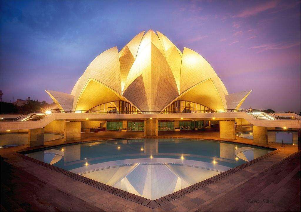 "Lotus Temple illuminated with yellow lights at night." Delhi India