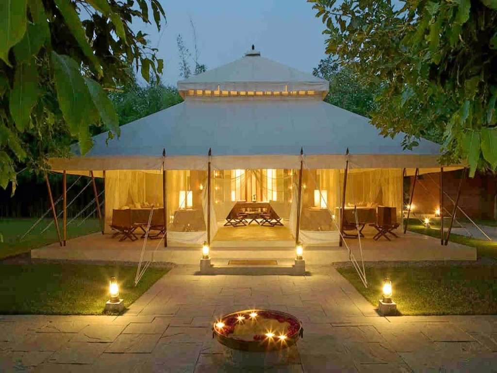 "Luxury tent with glowing interiors amidst the beautiful South Indian landscape at night, offering a unique and unforgettable glamping experience."