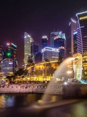 Merlion statue in Singapore illuminated with colorful lights in the night