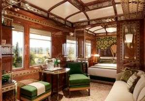 Luxury train compartment of Venice Simplon Orient Express with comfortable seating, elegant decor and scenic window view"