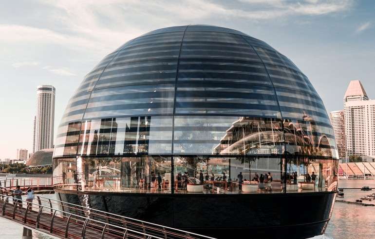 "The Apple Marina Bay Sands store in Singapore, a unique dome-shaped building floating on water, with the city skyline in the background."